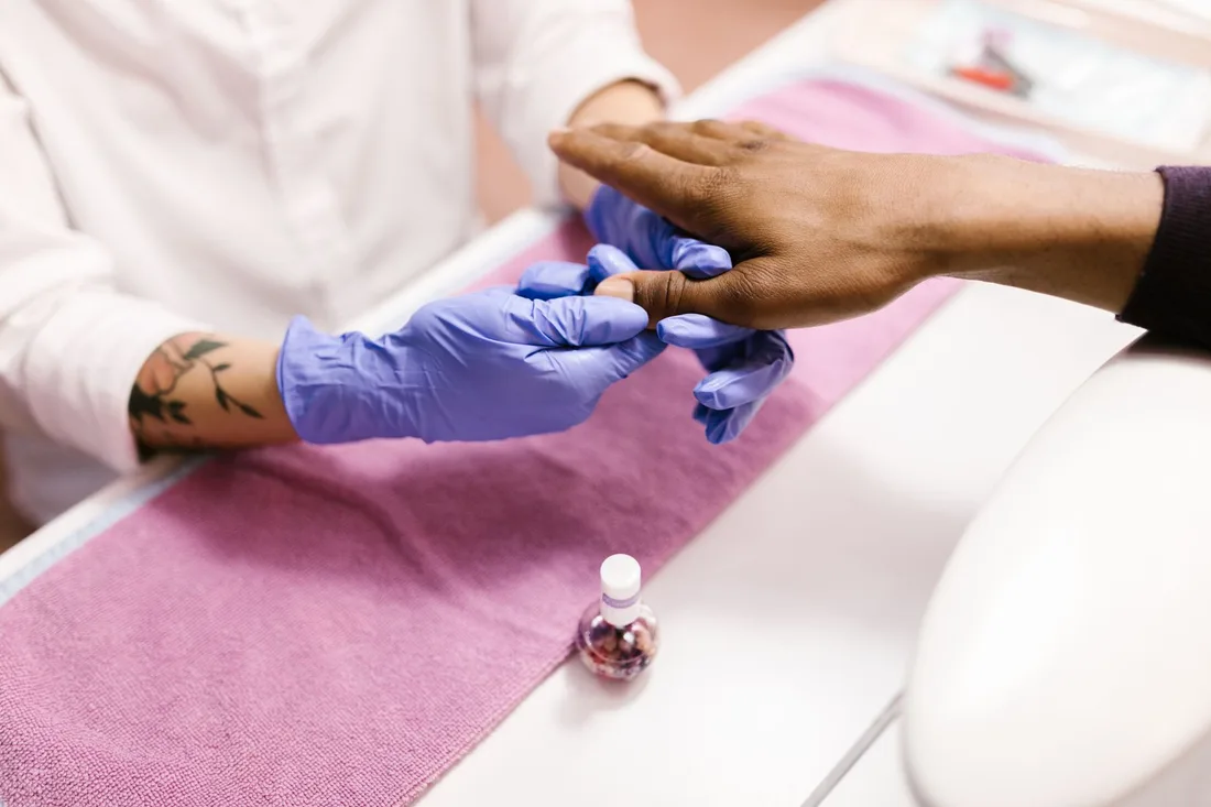 Close-up of a manicure service with blue latex gloves, emphasizing hygiene and care. Photo by RDNE Stock project on Pexels