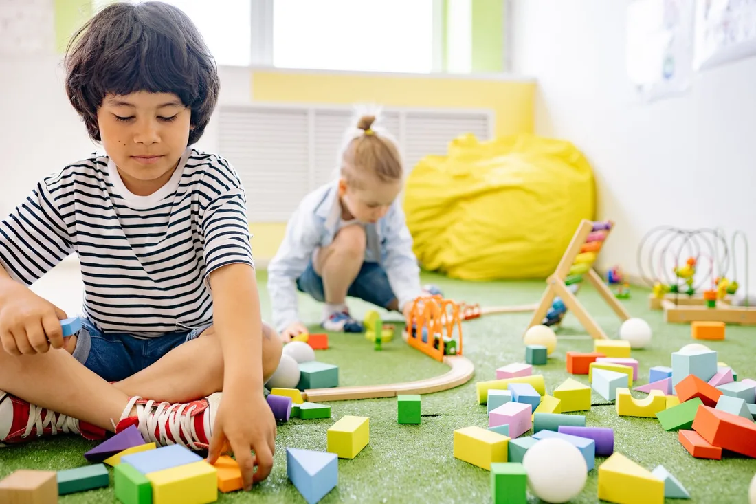 Children playing together with colourful building blocks on a classroom floor. Photo by Yan Krukau on Pexels