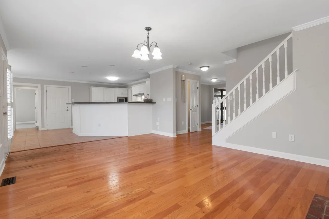 Newly finished open plan home interior with polished wood floors and staircase. Photo by Curtis Adams on Pexels