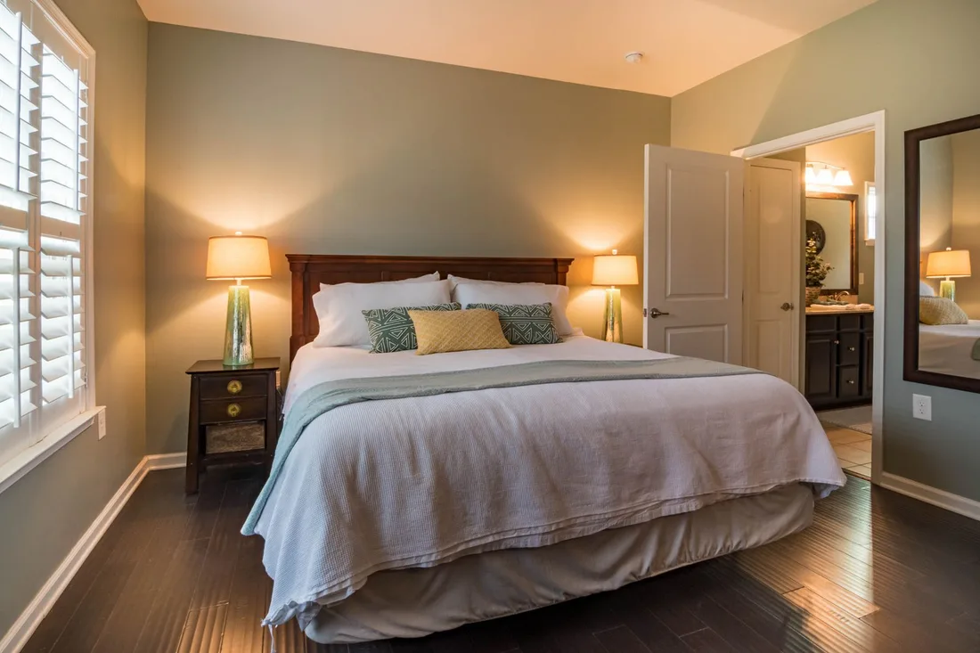 Warmly lit bedroom with a neatly made bed and bedside lamps. Photo by Curtis Adams on Pexels