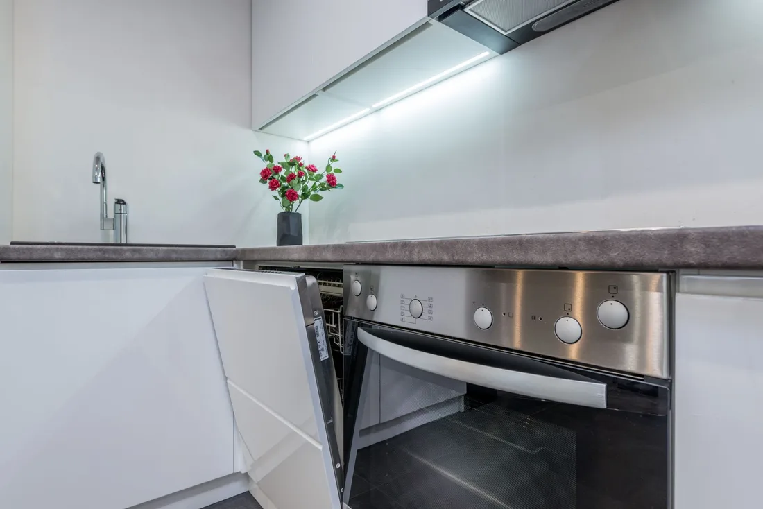 Clean built-in oven with open door in a bright white kitchen. Photo by Max Vakhtbovych on Pexels