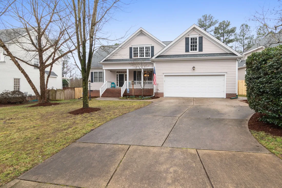 Suburban house with a two car garage and clean concrete driveway. Photo by Curtis Adams on Pexels