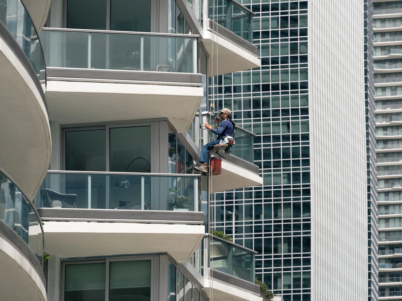 Window cleaner on ropes working on the balconies of a tall apartment tower. Photo by Dmytro Koplyk on Pexels
