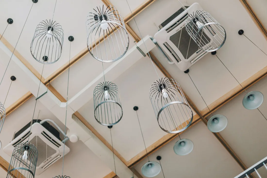 Ceiling mounted air conditioning cassettes in a stylish room with pendant lights. Photo by FOX ^.ᆽ.^= ∫ on Pexels