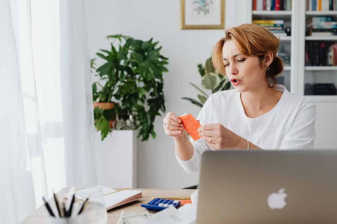Woman at a laptop reviewing a utility bill at her home desk. Photo by https://kaboompics.com/ on Pexels