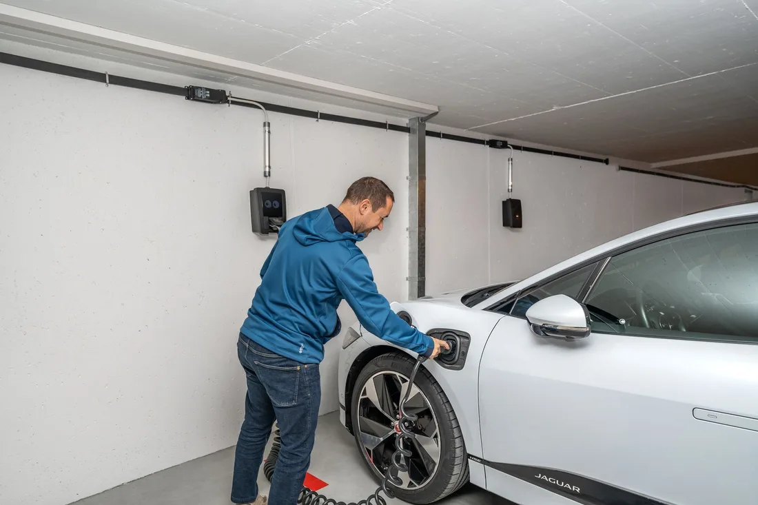 Man plugging in a white electric car in a clean home garage. Photo by smart-me AG on Pexels