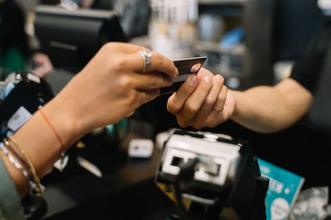 Close-up of hands completing a payment transaction at a retail checkout using a bank card. Photo by Anna Tarazevich on Pexels
