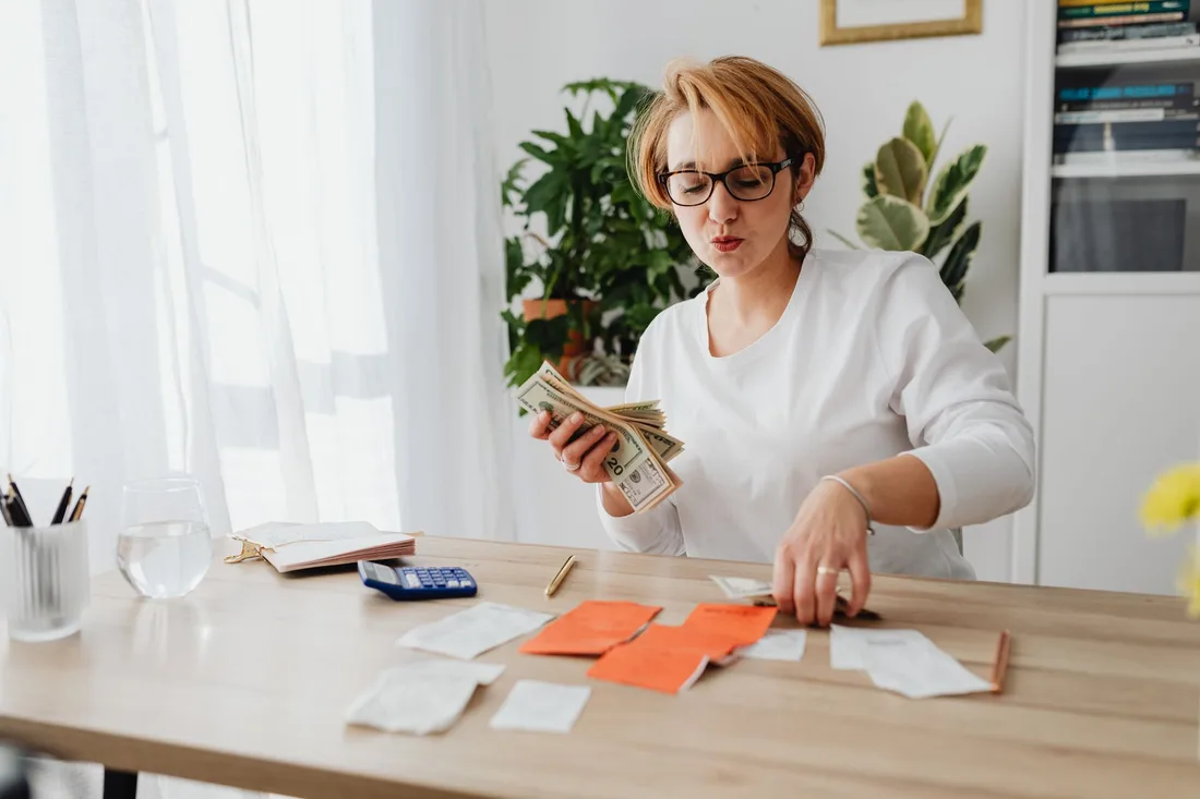 Small business owner sorting receipts and invoices at a bright desk. Photo by https://kaboompics.com/ on Pexels