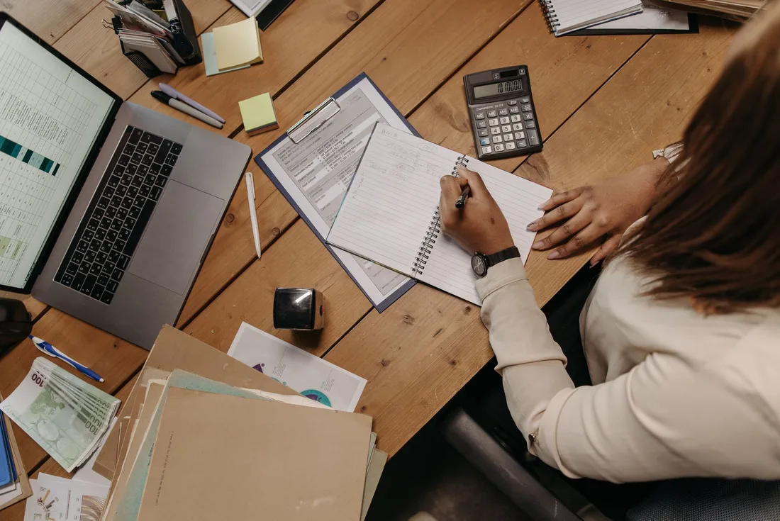Organized desk with laptop, calculator, receipts and notebook seen from above. Photo by Pavel Danilyuk on Pexels