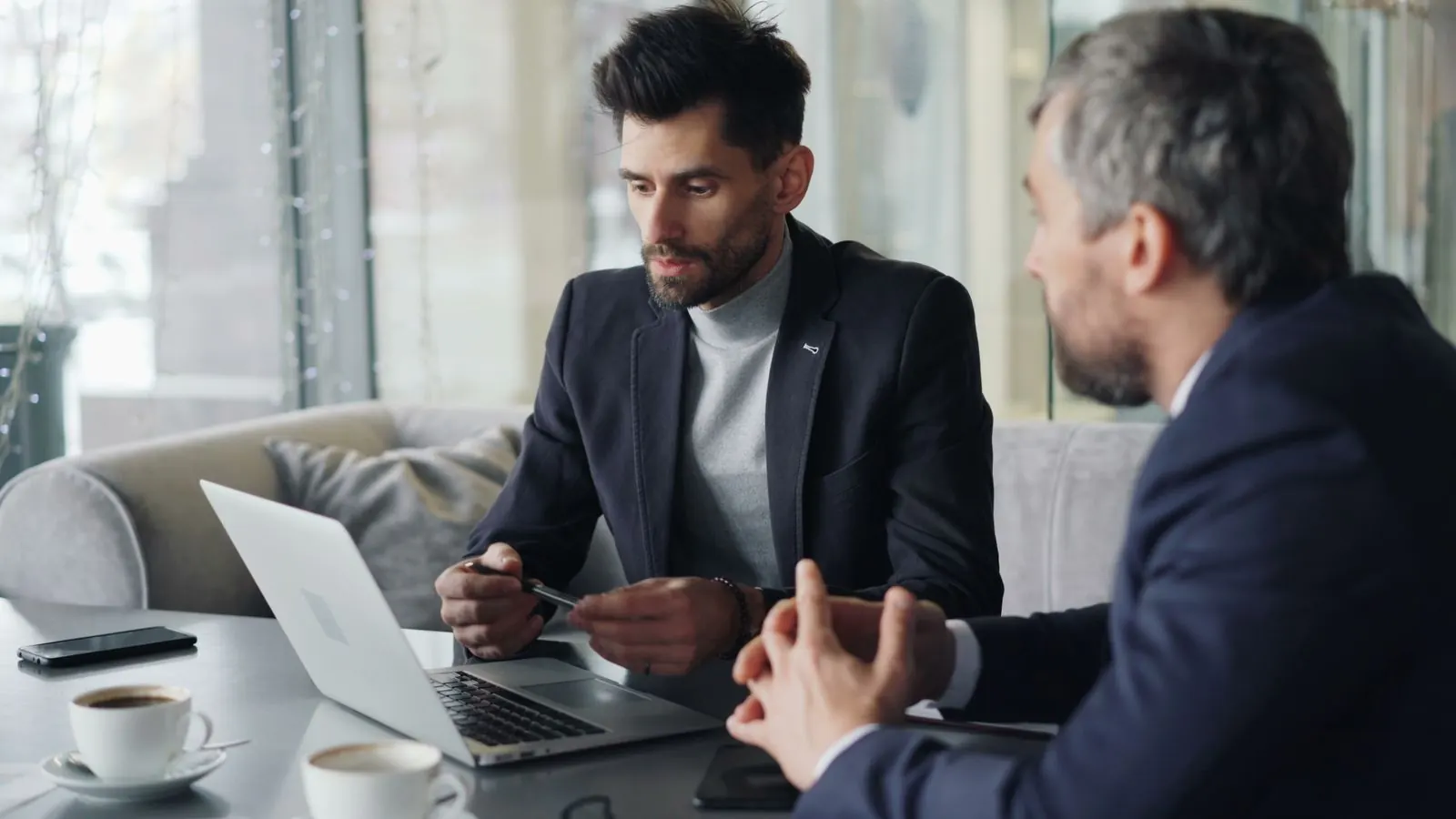 Two people in business clothes reviewing a laptop at a table. Photo by Vitaly Gariev on Pexels