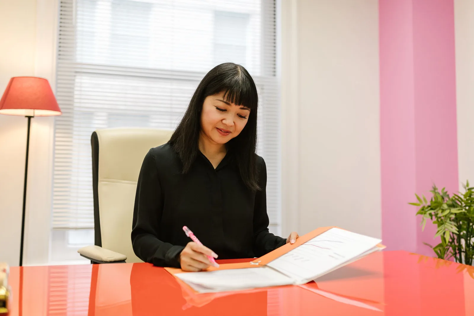 Company secretary signing corporate documents at a desk in a bright office in Singapore. Photo by RDNE Stock project on Pexels