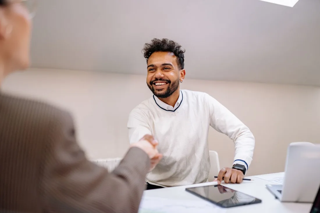 Smiling business owner shaking hands with an accountant at a bright desk. Photo by Yan Krukau on Pexels