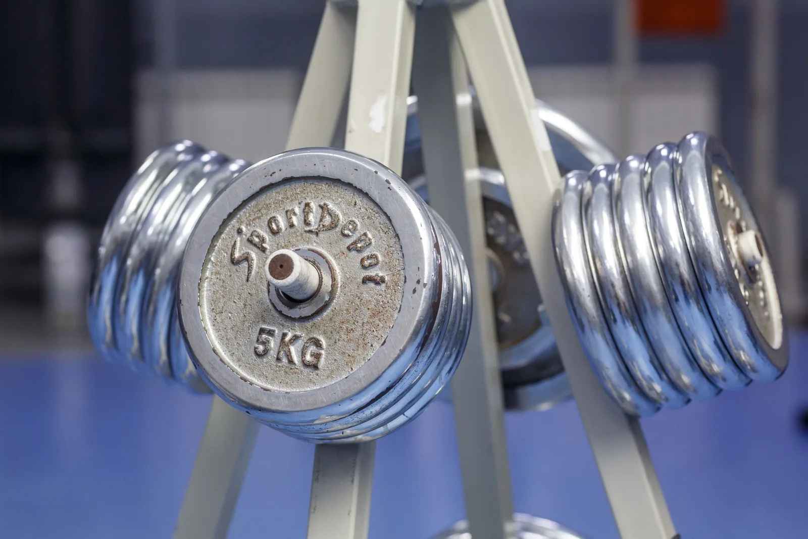 Close-up of chrome dumbbells on a gym rack displaying 5kg weights. Photo by Kristijan Furstner on Pexels