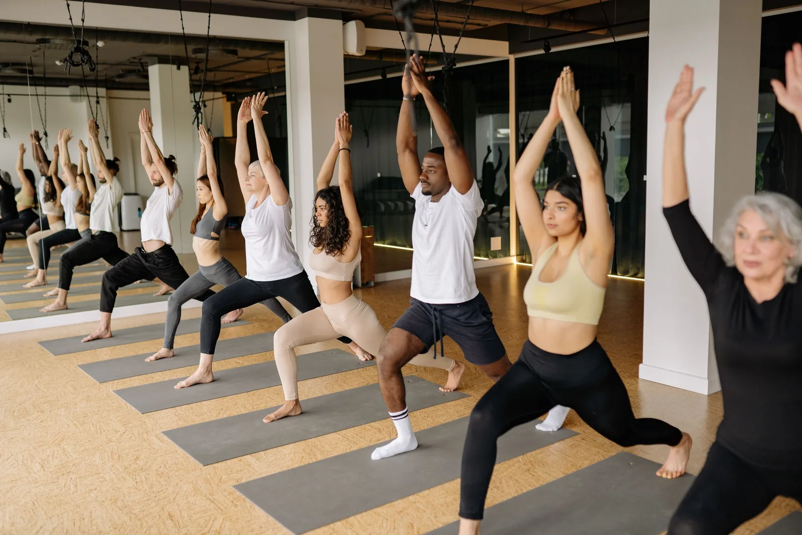 Instructor leading a yoga class through a lunge pose in a bright studio. Photo by Yan Krukau on Pexels