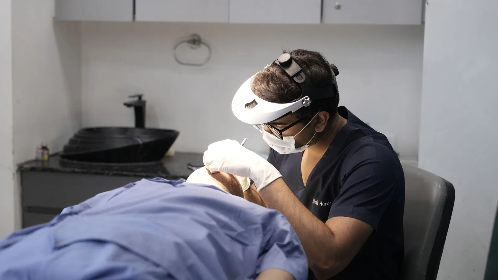 Dermatologist wearing a headlamp examining a patient's face in a clinic. Photo by Dr. Haror's  Wellness on Pexels