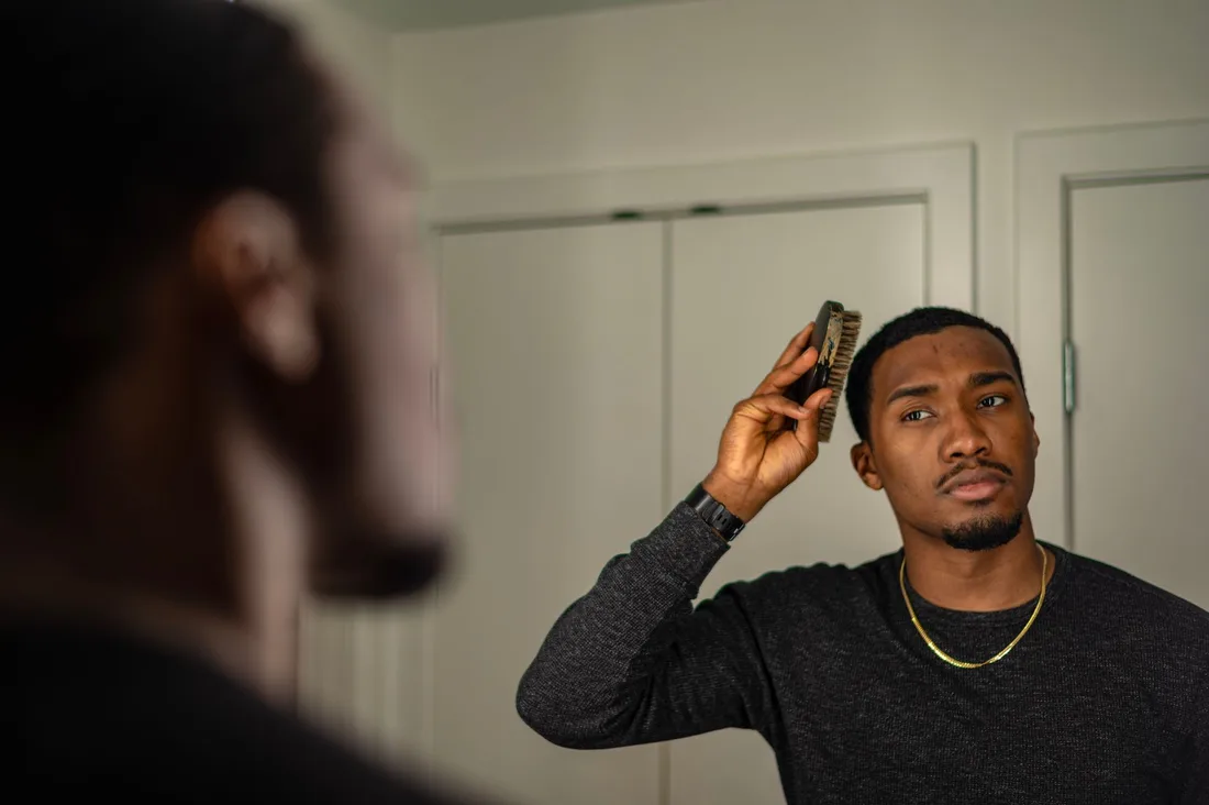Man checking his hairline in a mirror. Photo by PNW Production on Pexels