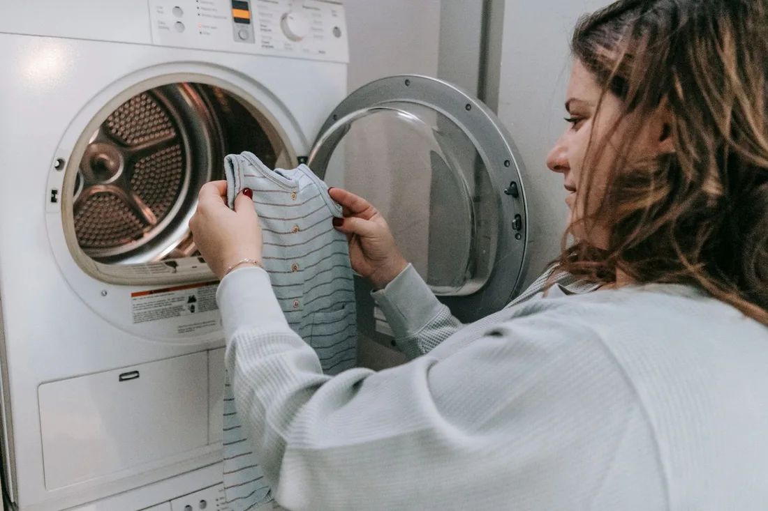 Homeowner checking the drum of her washing machine at home. Photo by Sarah  Chai on Pexels