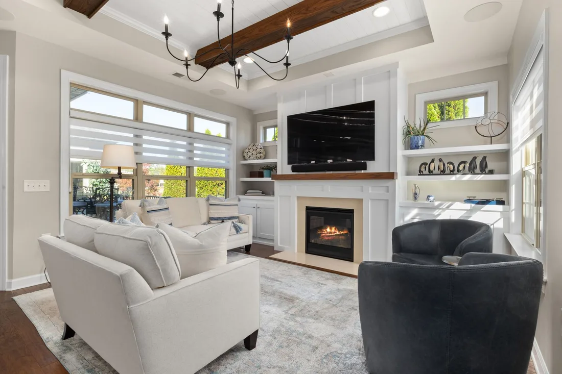 Bright living room with white sofas, a fireplace and blinds on the windows. Photo by Curtis Adams on Pexels