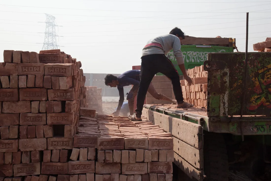 Men load bricks onto a truck at a construction site in Gabtoli, Dhaka. Photo by M Mahbub A Alahi on Pexels