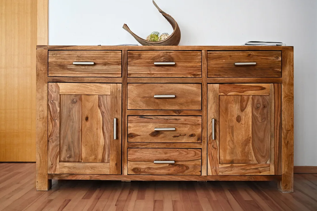 Finished solid wood sideboard cabinet with drawers and doors in a bright room. Photo by adrian vieriu on Pexels