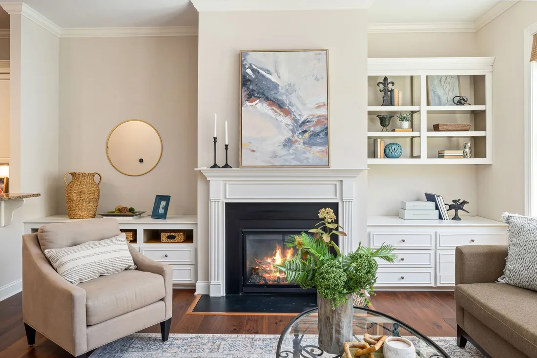 Living room with a lit fireplace, white mantel, built-in shelves and armchair in the UK. Photo by Curtis Adams on Pexels