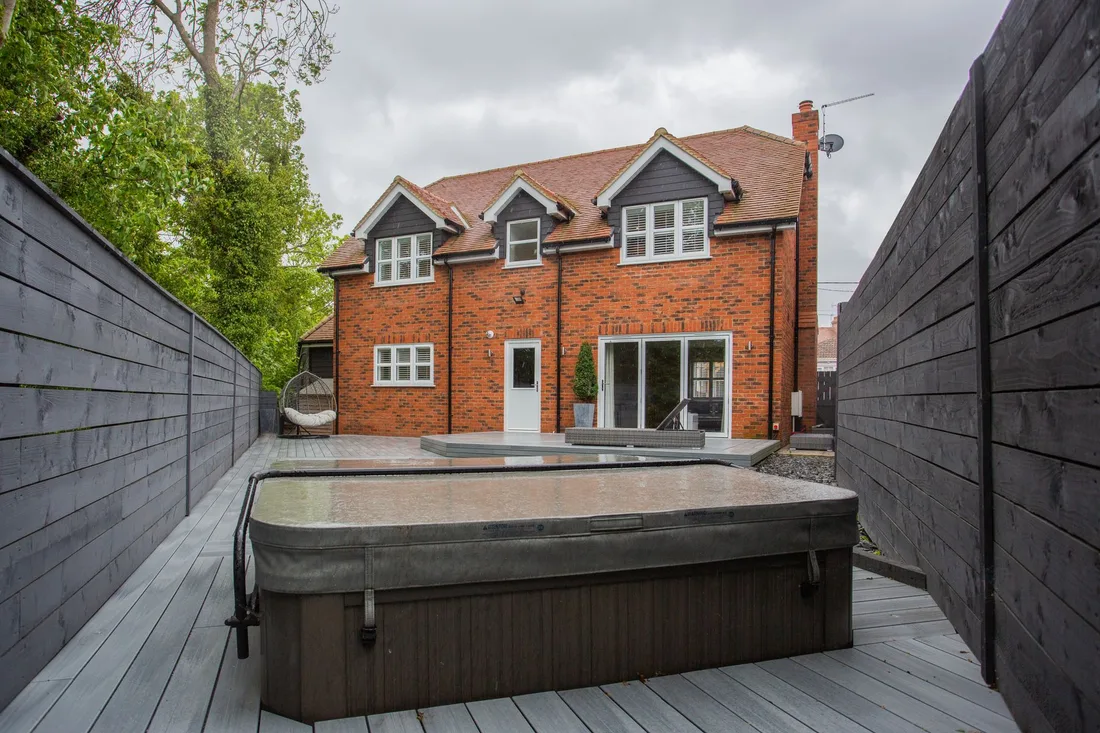 A picturesque backyard view of a modern brick house with a jacuzzi. Photo by Photographer Liam Gillan on Pexels