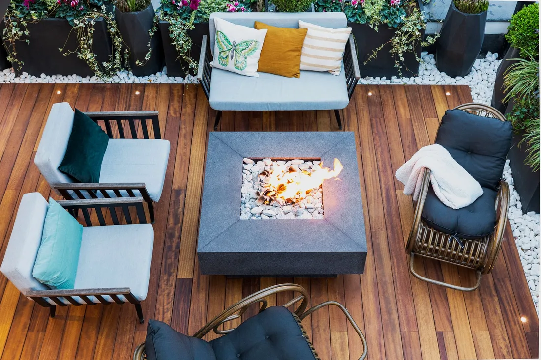 Finished wooden deck patio with a fire pit and comfortable outdoor seating. Photo by Nasim Didar on Pexels