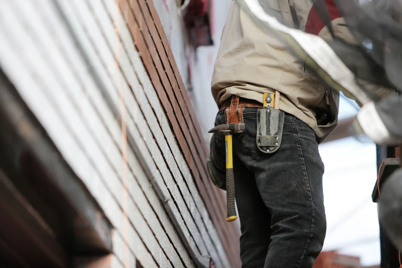 Close-up of a construction worker with hammer and tools, focused on the job. Photo by Life Of Pix on Pexels