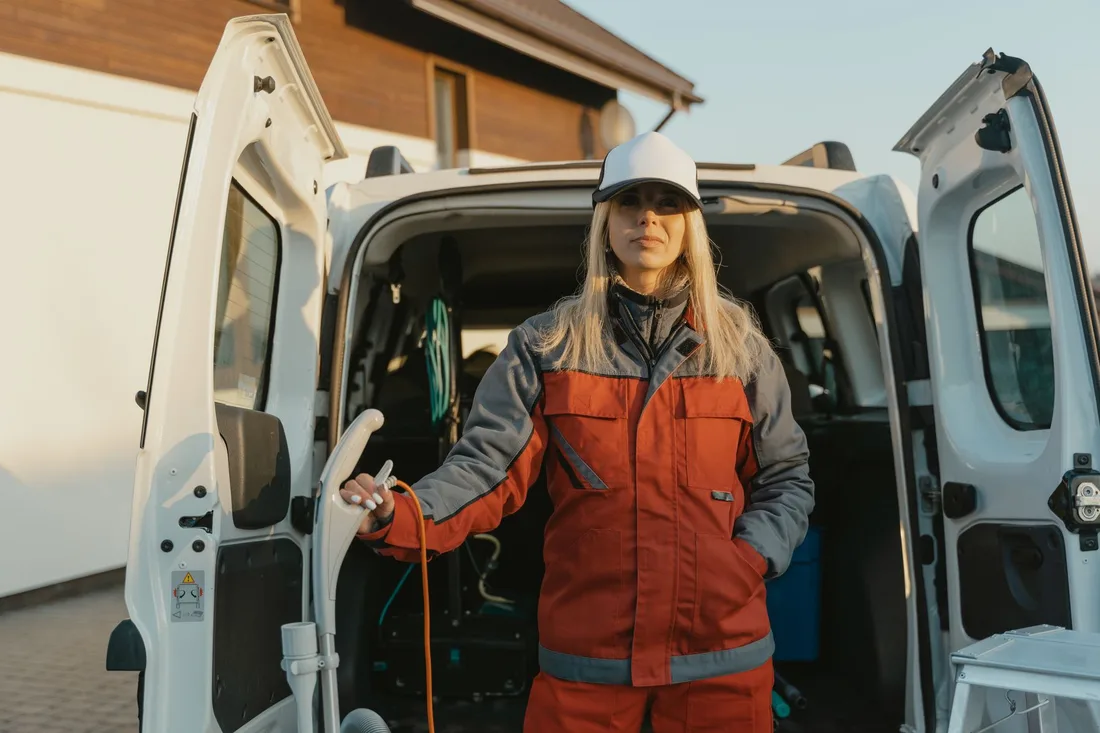 Female worker in uniform standing by a cleaning service van outdoors during the day. Photo by Tima Miroshnichenko on Pexels