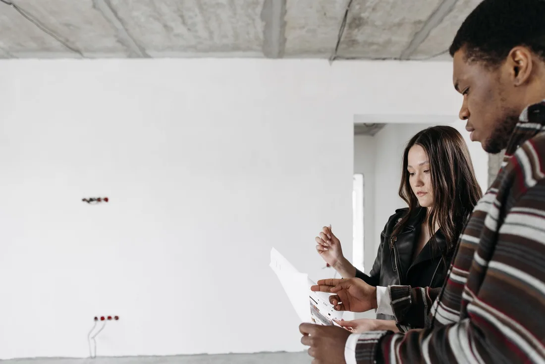 Homeowners discussing wall wiring and socket positions with a contractor in a bright empty room. Photo by Pavel Danilyuk on Pexels