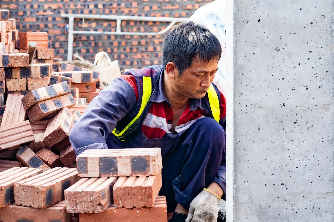 Focused worker laying bricks at construction site in Hải Phòng. Photo by Thanh Long Bùi on Pexels