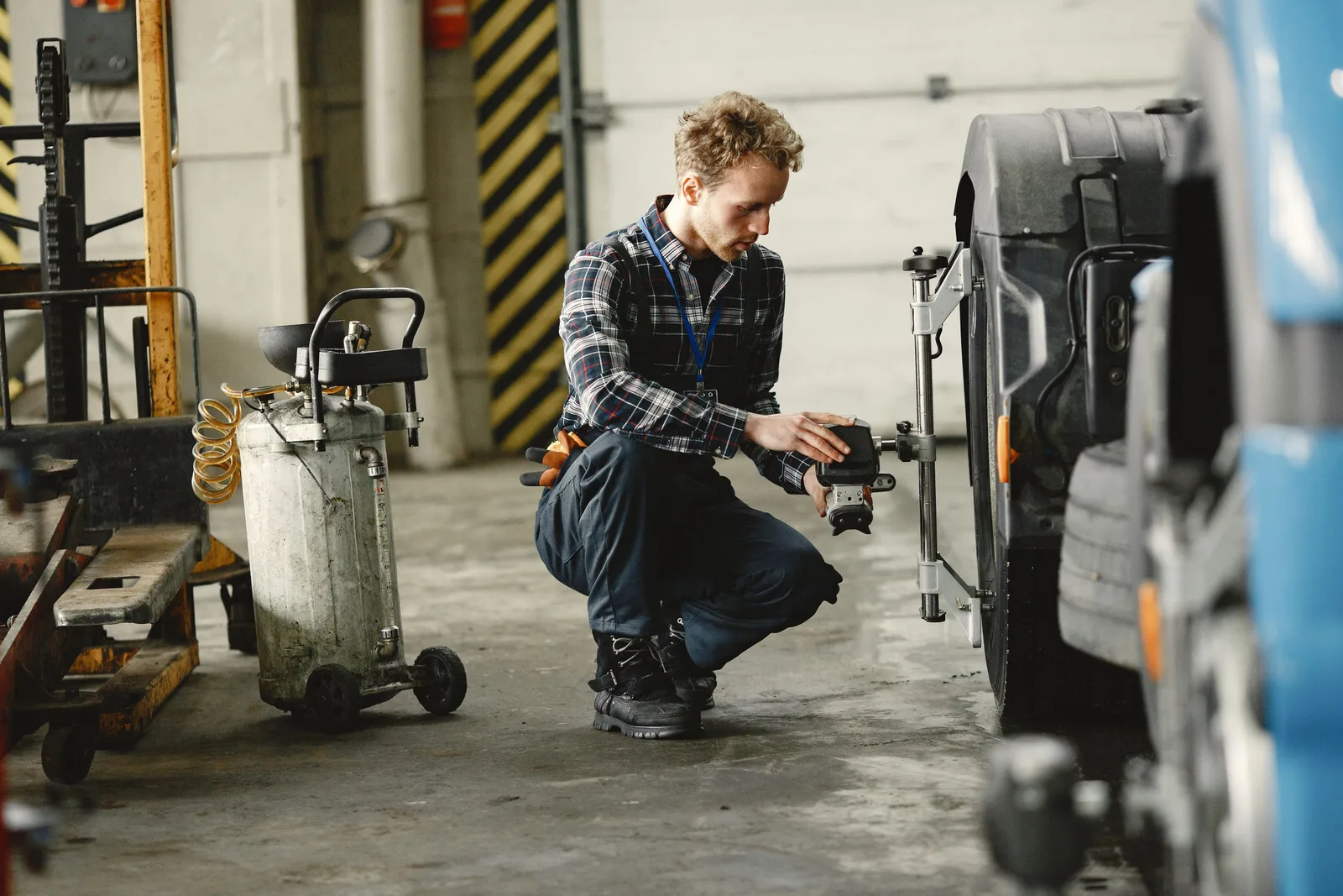 A mechanic in a workshop aligning truck wheels, focusing on precision and repair. Photo by Gustavo Fring on Pexels