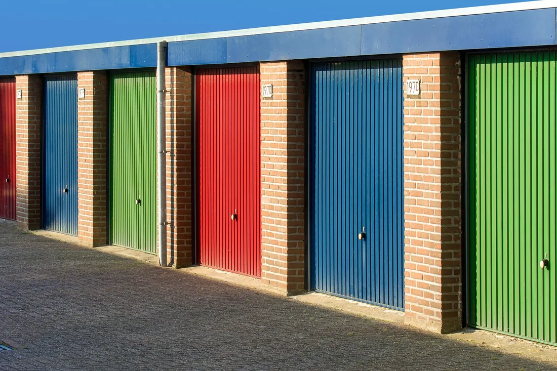 Vibrant urban scene showcasing colorful garage doors aligned in a row under clear skies. Photo by Jan van der Wolf on Pexels