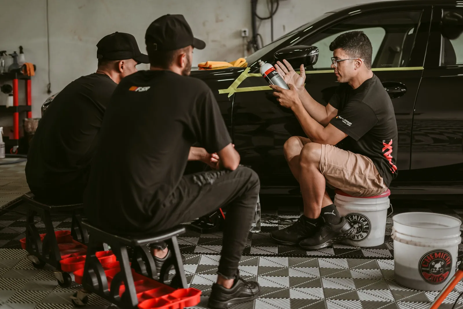 Men discussing car detailing techniques in a professional workshop setting. Photo by Geancarlo Peruzzolo on Pexels