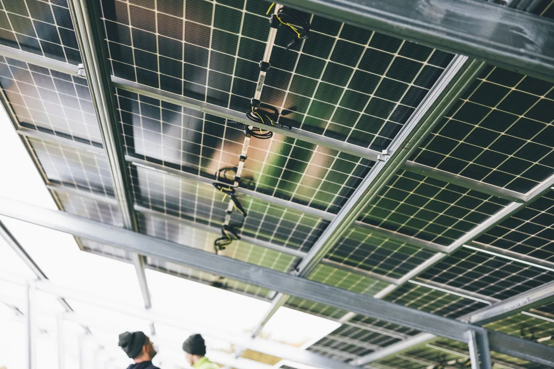Close-up of solar panels being installed outdoors with technicians visible. Photo by Markus Spiske on Pexels