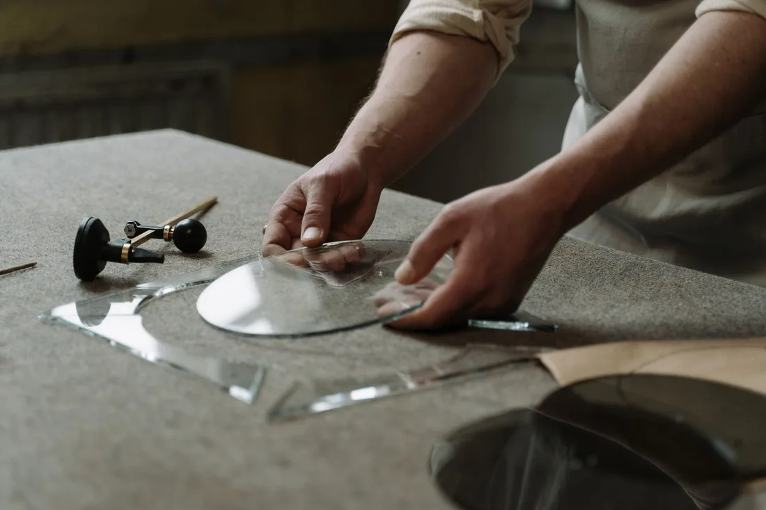 Close-up of artisan hands crafting glass pieces in a workshop, showcasing skill and precision. Photo by cottonbro studio on Pexels