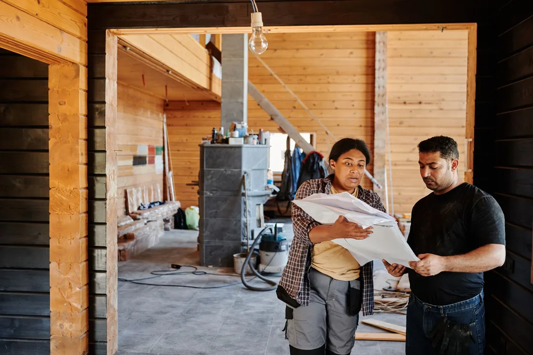 Inspector and homeowners reviewing documents together inside a house under renovation. Photo by Mikael Blomkvist on Pexels