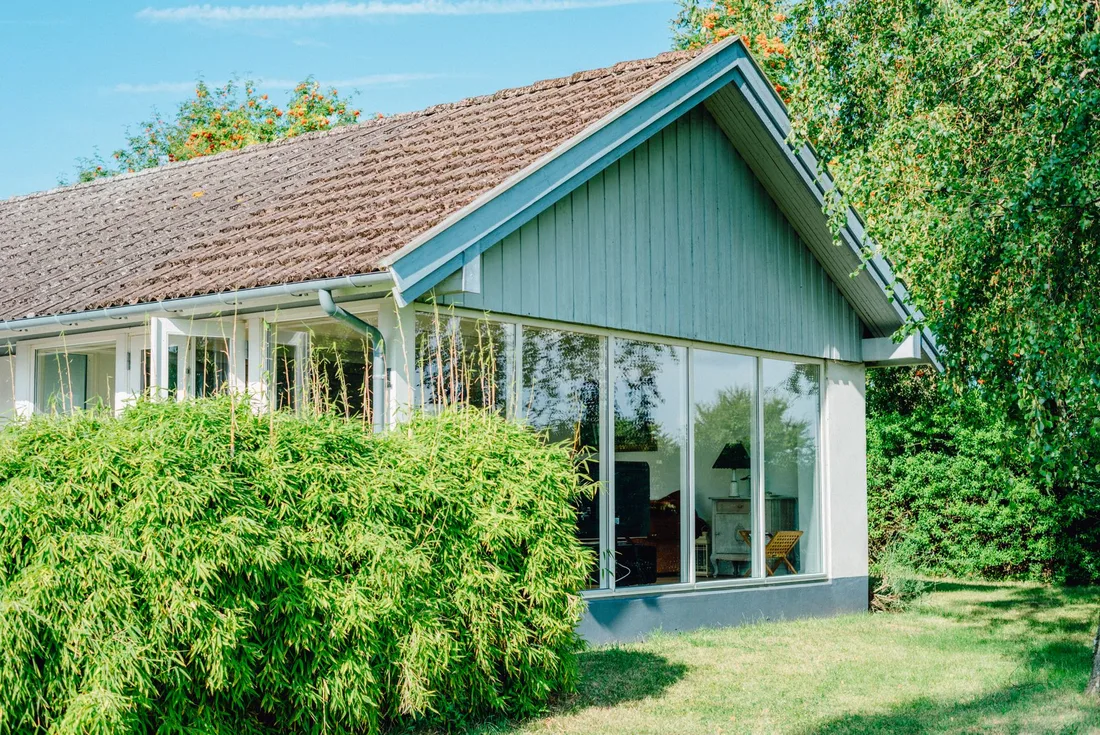 Renovated single-storey house with a glazed extension surrounded by greenery. Photo by Lara on Pexels