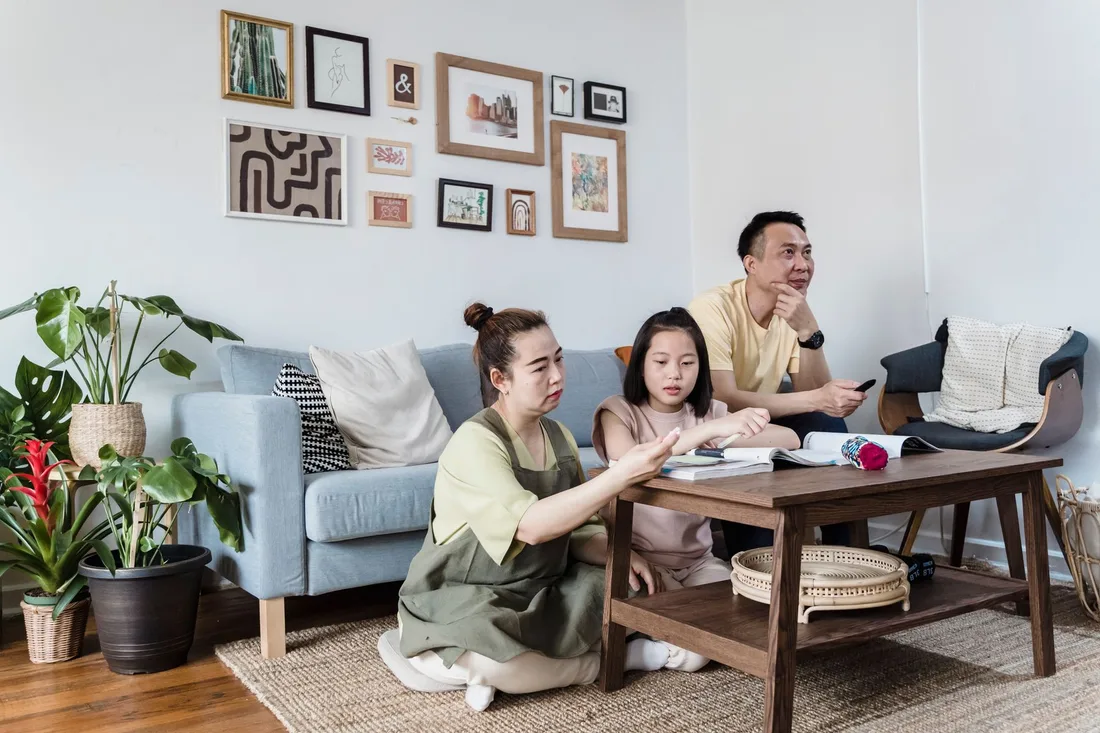 Smiling family relaxing together on a sofa in a bright, comfortable living room. Photo by Annushka  Ahuja on Pexels