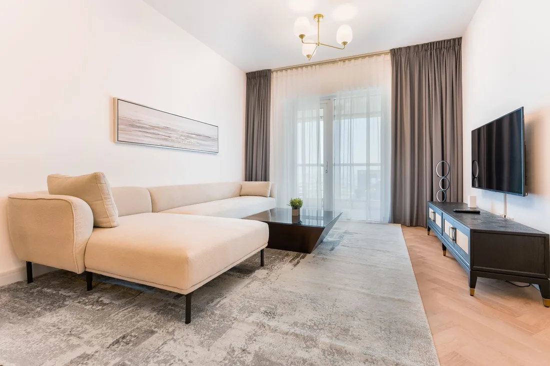 Elegant living room with cream sectional sofa, drapes and modern decor. Photo by Alan Antony on Pexels
