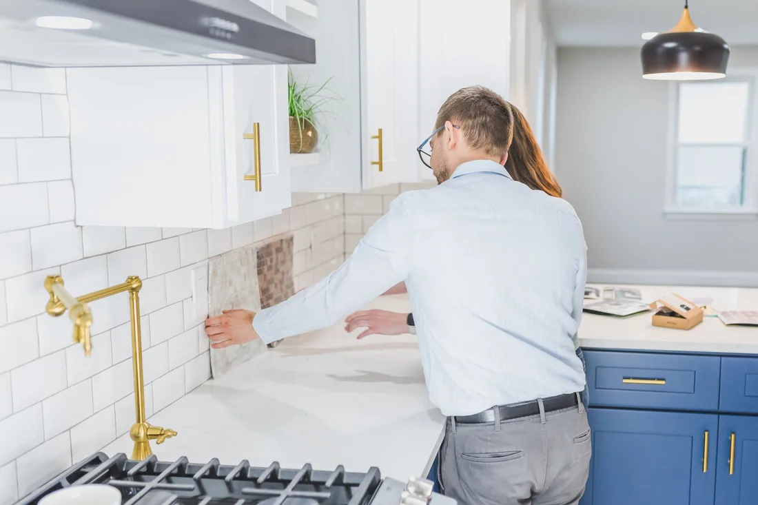 A couple choosing tiles in a modern kitchen setting, discussing renovation ideas. Photo by RDNE Stock project on Pexels