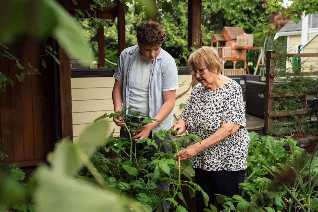Homeowners tending plants together in a lush backyard garden near the house. Photo by Jelly Marketing on Pexels