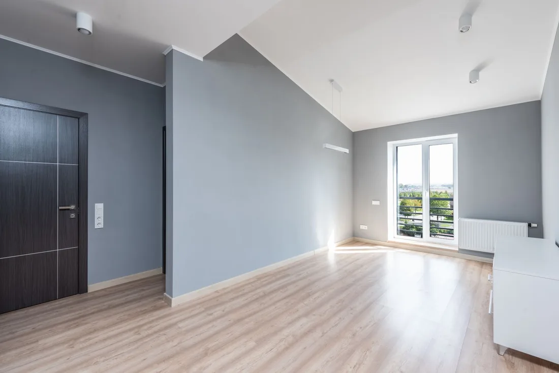 Bright empty room with freshly painted gray walls, wood floor and a window. Photo by Max Vakhtbovych on Pexels