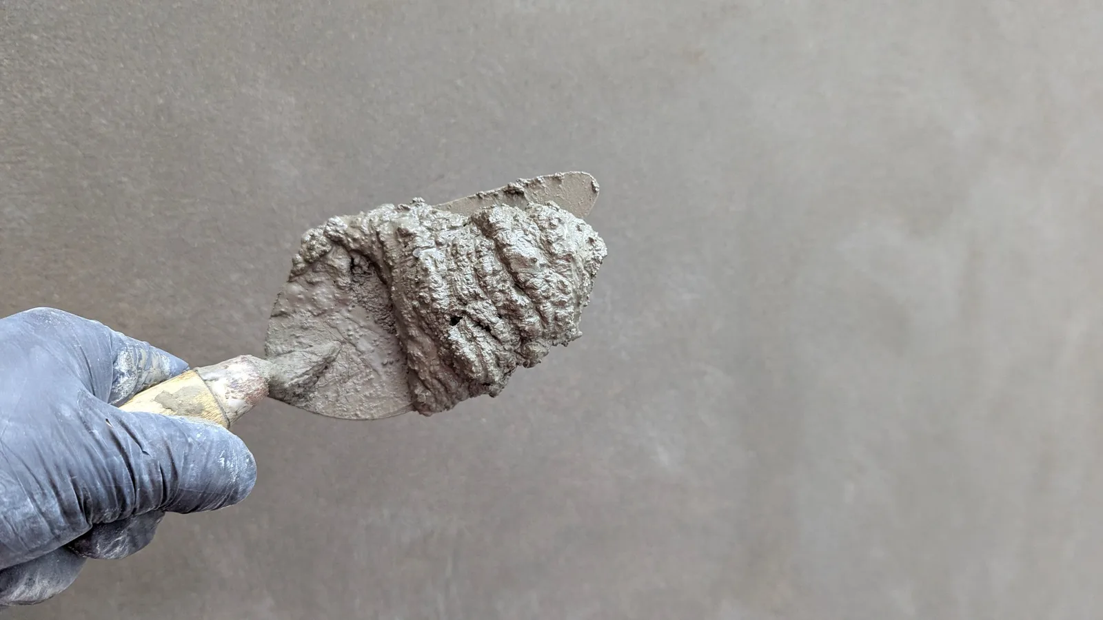 Close-up of a hand holding a trowel with cement, perfect for construction themes. Photo by David Antonio Cruz Naira on Pexels