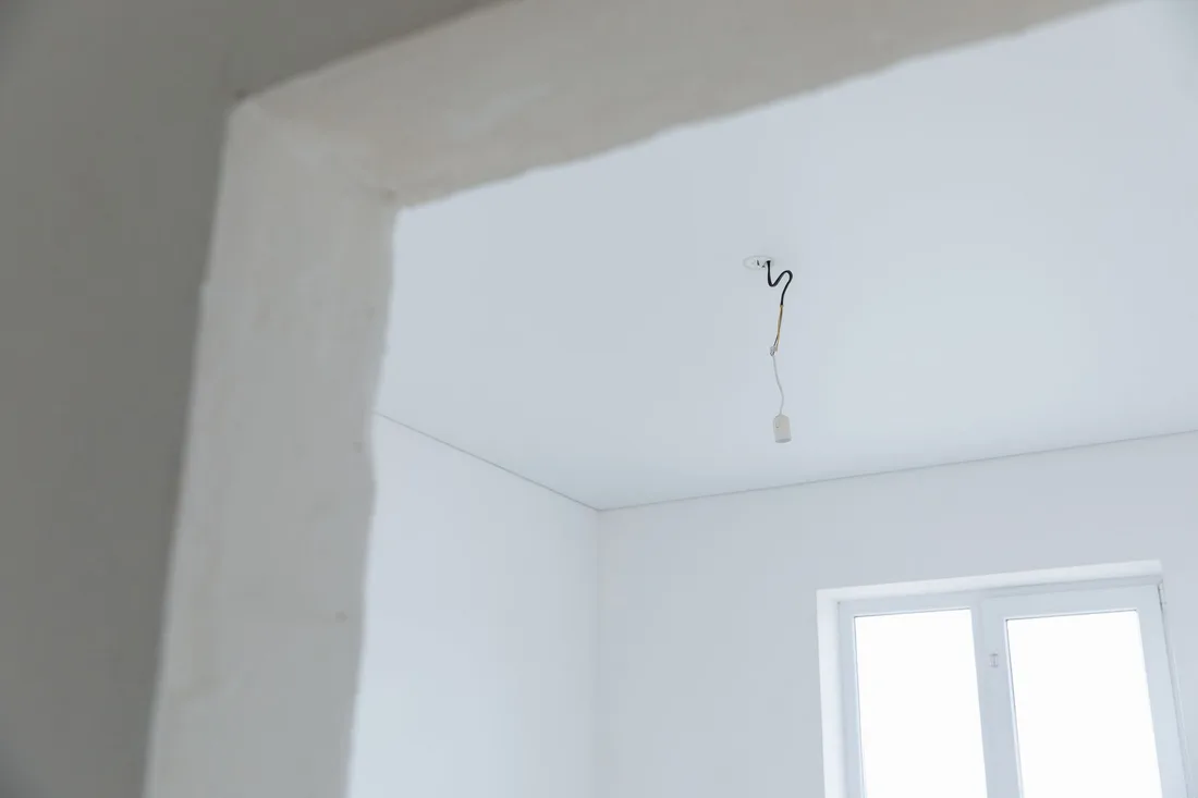 Smooth finished plastered walls and ceiling in a bright room with a window. Photo by Thirdman on Pexels