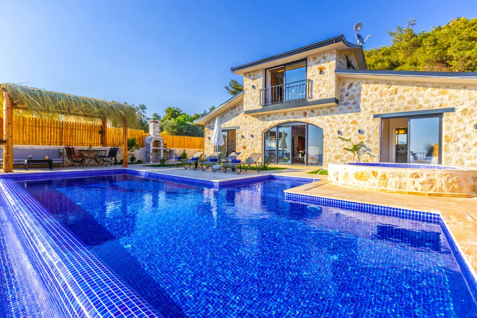 Backyard swimming pool with blue water beside a modern house. Photo by Ahmet ÇÖTÜR on Pexels