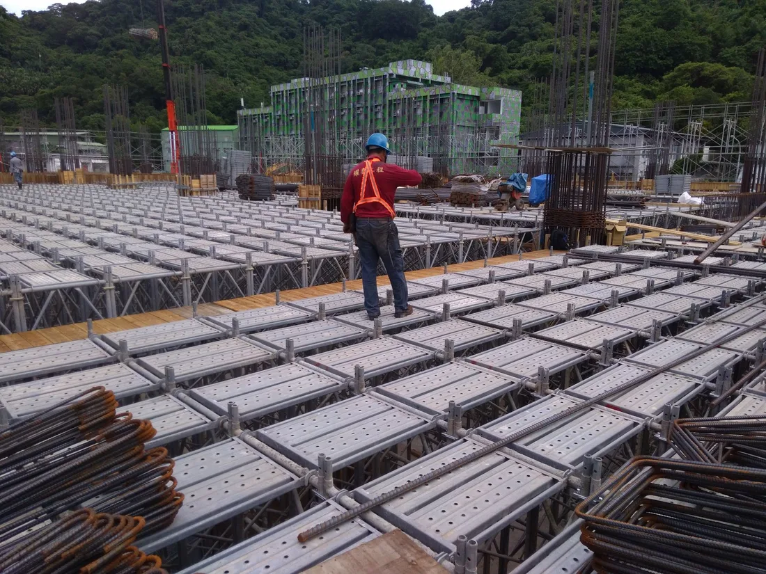 A construction worker inspects scaffolding at a building site in Taiwan, ensuring safety and progress. Photo by MELVIN 小確幸 on Pexels