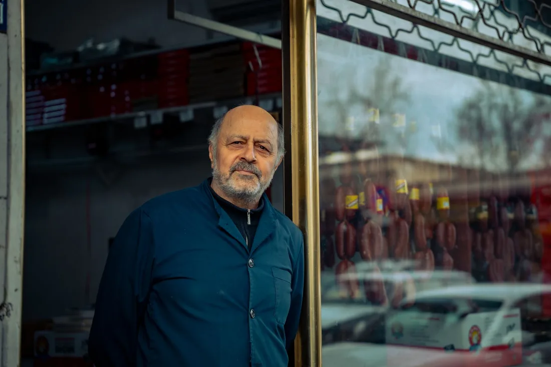 Elderly butcher standing proudly outside his traditional meat shop. Photo by Zeynep Sude  Emek on Pexels
