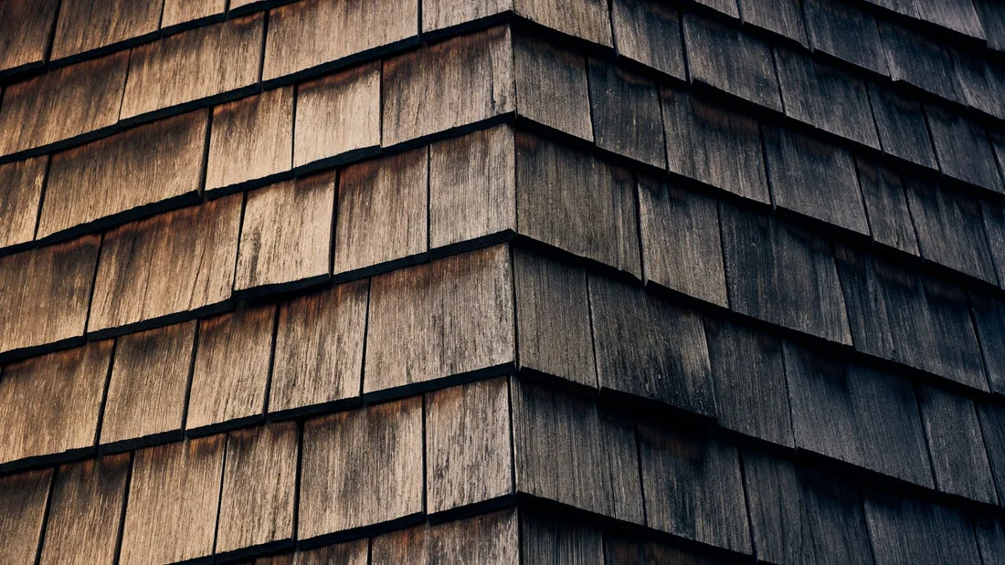 Detailed view of textured wooden shingles with a natural warm finish. Photo by Michael Markhof on Pexels