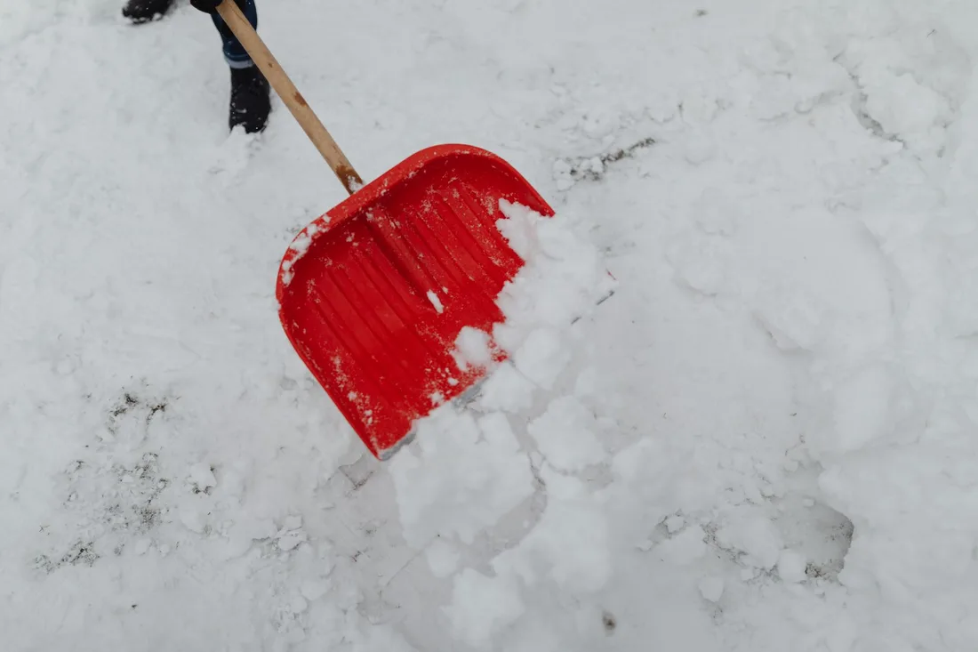 Red snow shovel clearing fresh snow, highlighting winter labor and cleanup. Photo by www.kaboompics.com on Pexels